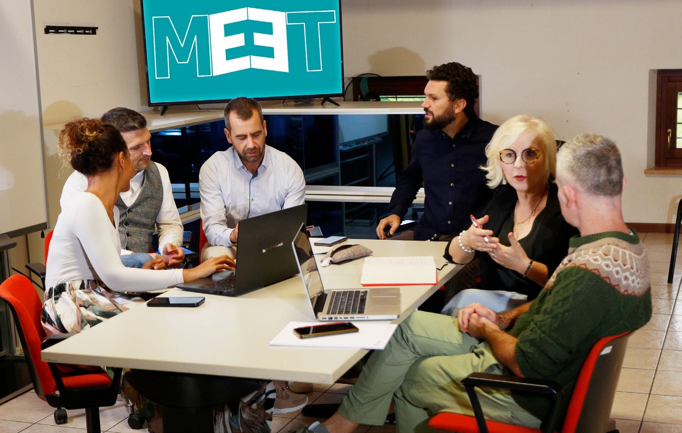 Il team di MEET riunito attorno a un tavolo di lavoro